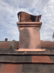 Habillage de cheminée en cuivre façonné et installé par BM couverture, spécialiste de la zinguerie à Charleval en Normandie.